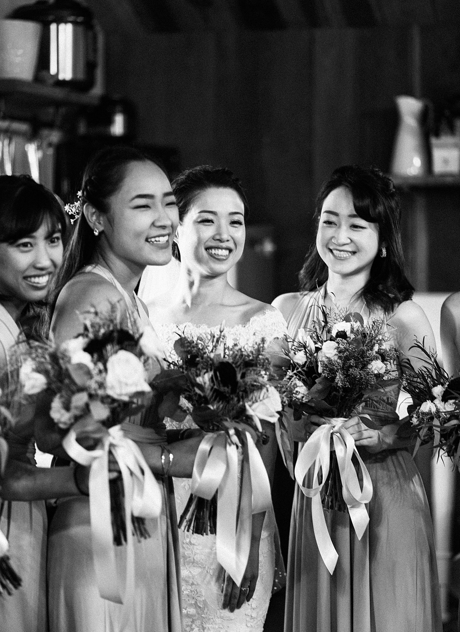 bride and bridesmaids are smiling towards the camera