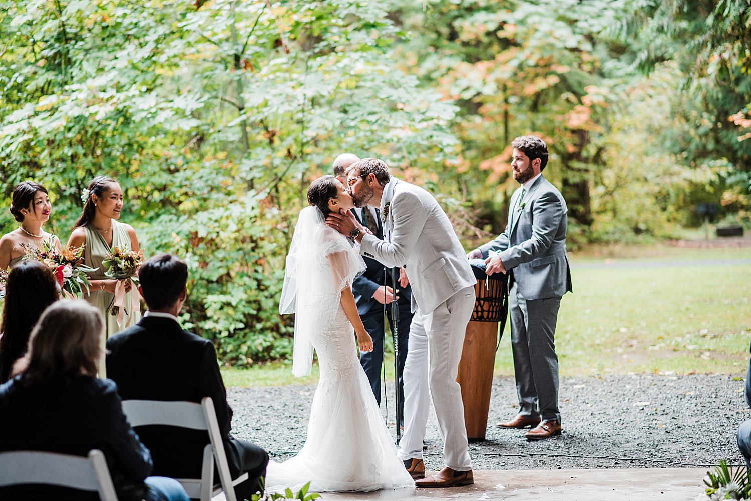 a groom is kissing his wife in front of all the guests